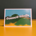 Postcard with 'Council Bluffs' text on a yellow surface and dark background