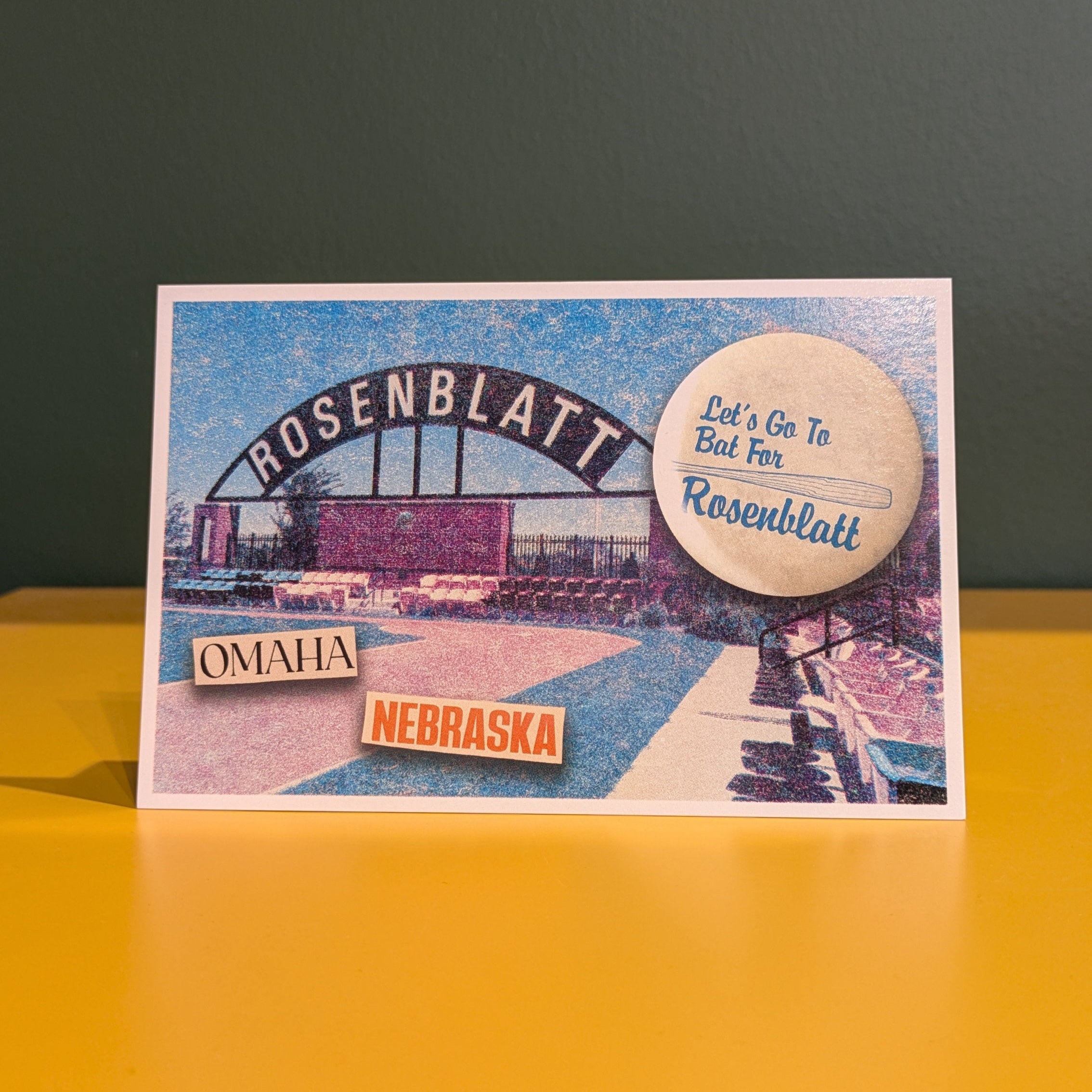 Postcard of Rosenblatt Stadium in Omaha, Nebraska on a yellow surface with a dark background