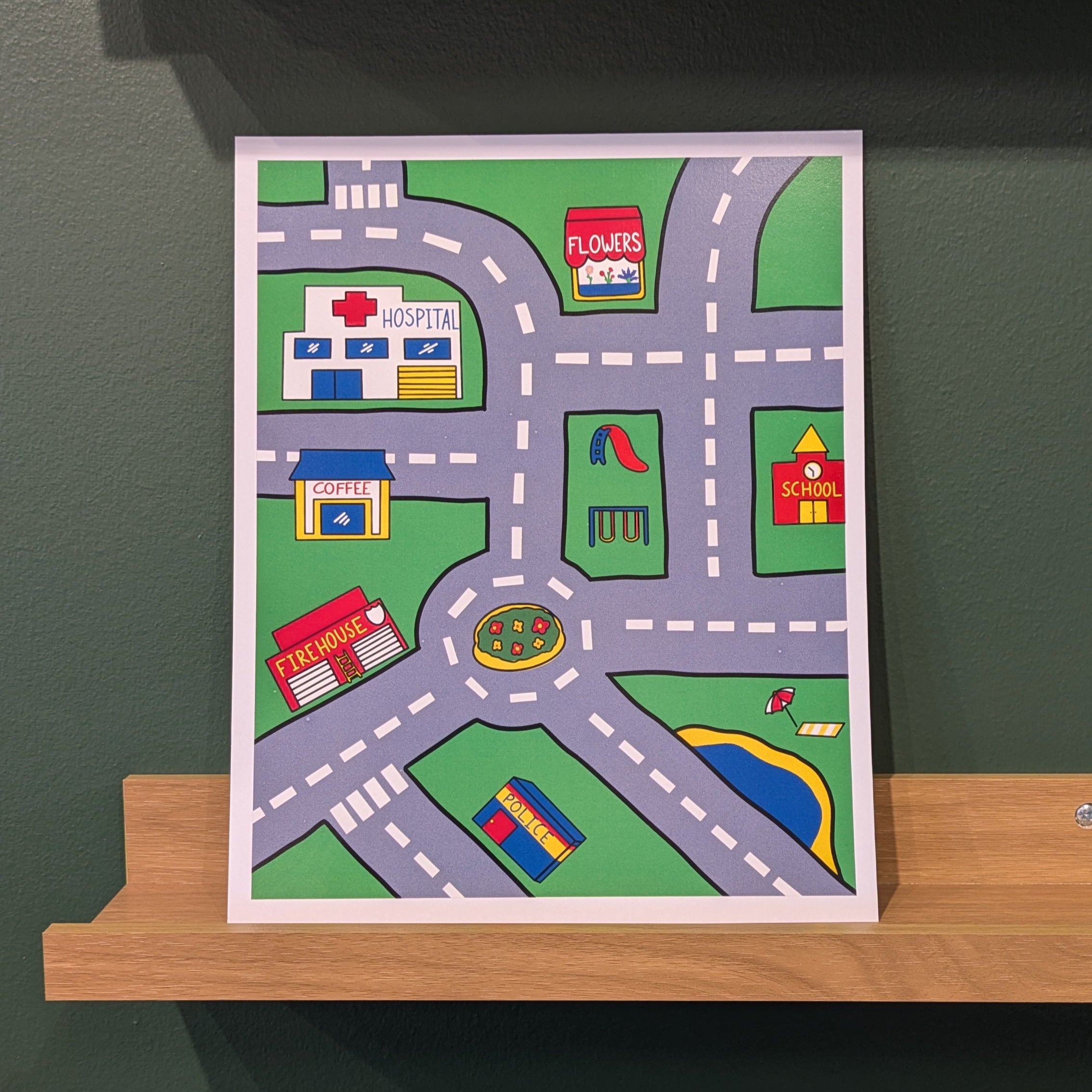 Colorful children's road map rug on a wooden shelf against a green wall.