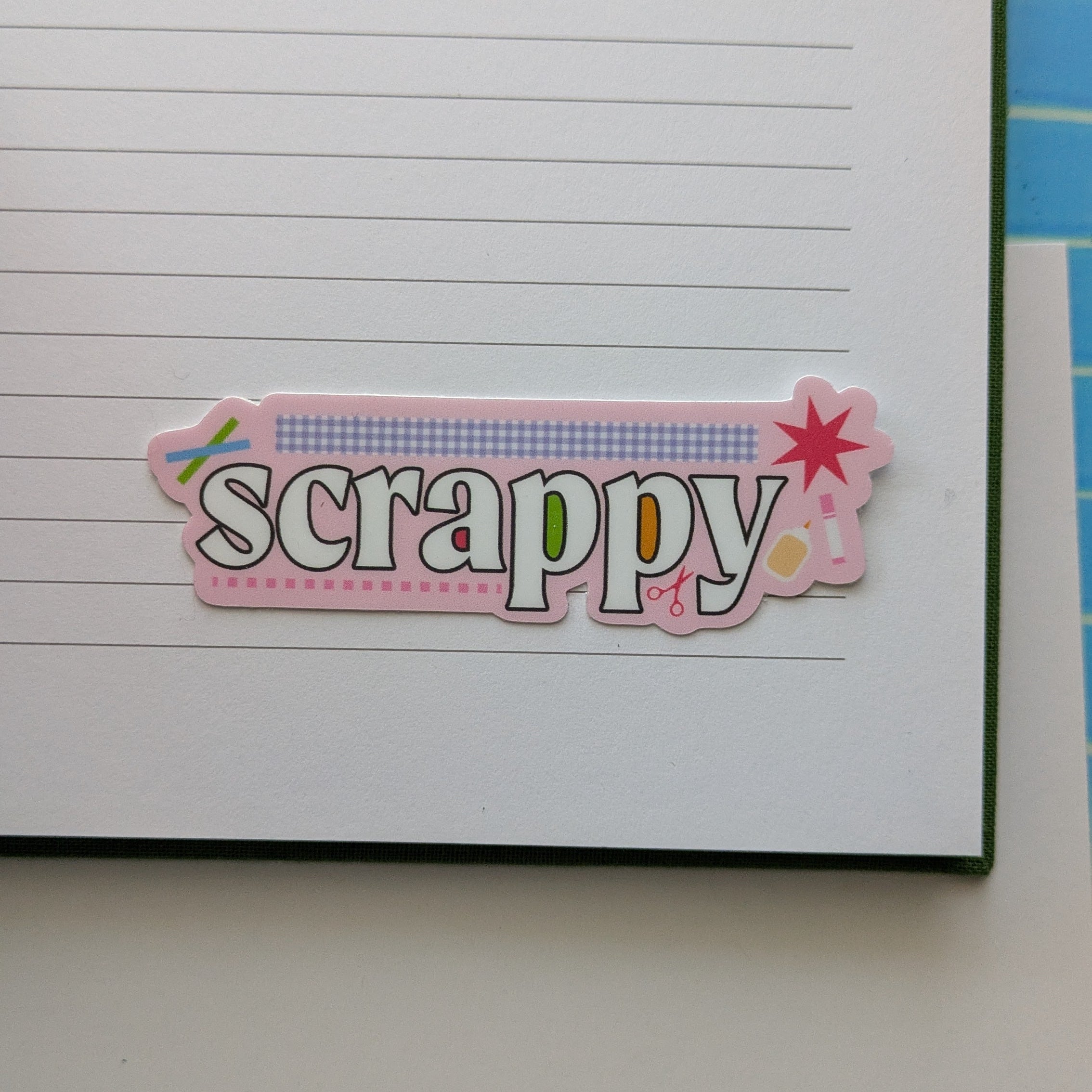 Colorful 'Scrappy' sticker on a lined notebook page