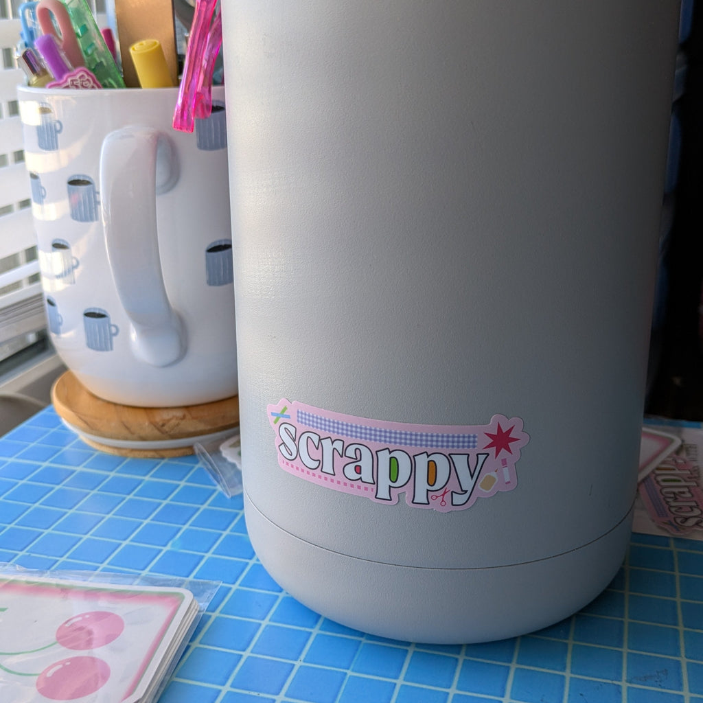 Gray bottle with 'scrappy' logo on a blue checkered surface