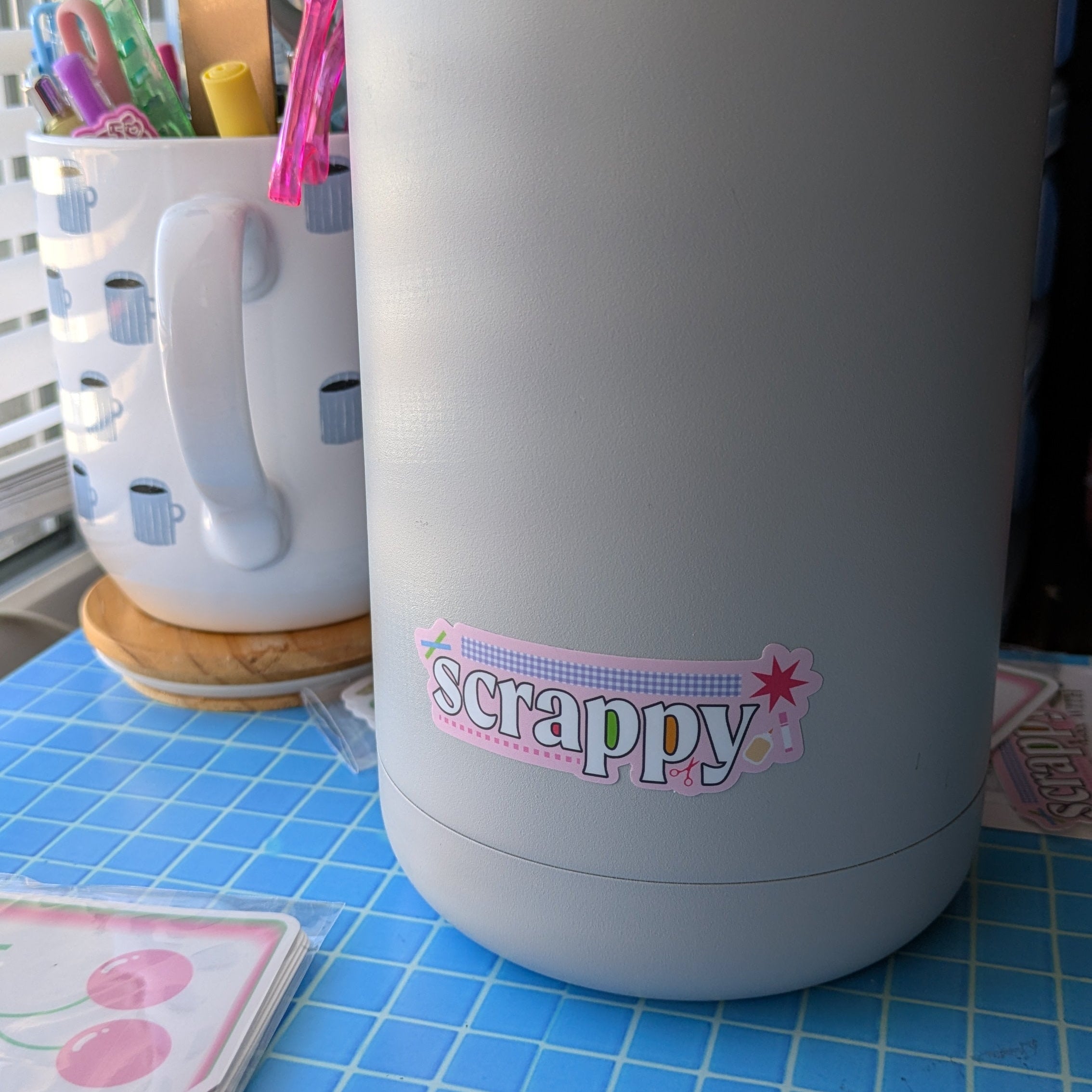 Gray bottle with 'scrappy' logo on a blue checkered surface