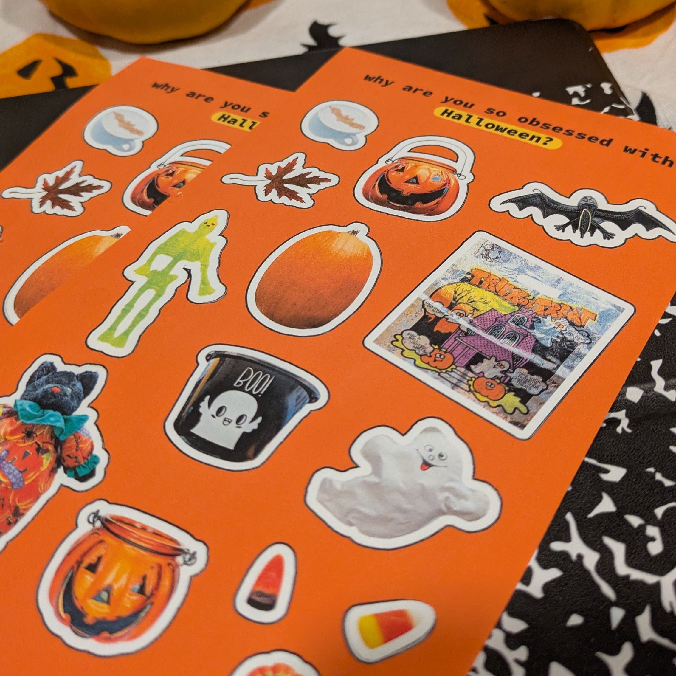 Halloween-themed stickers on an orange sheet with pumpkins in the background.