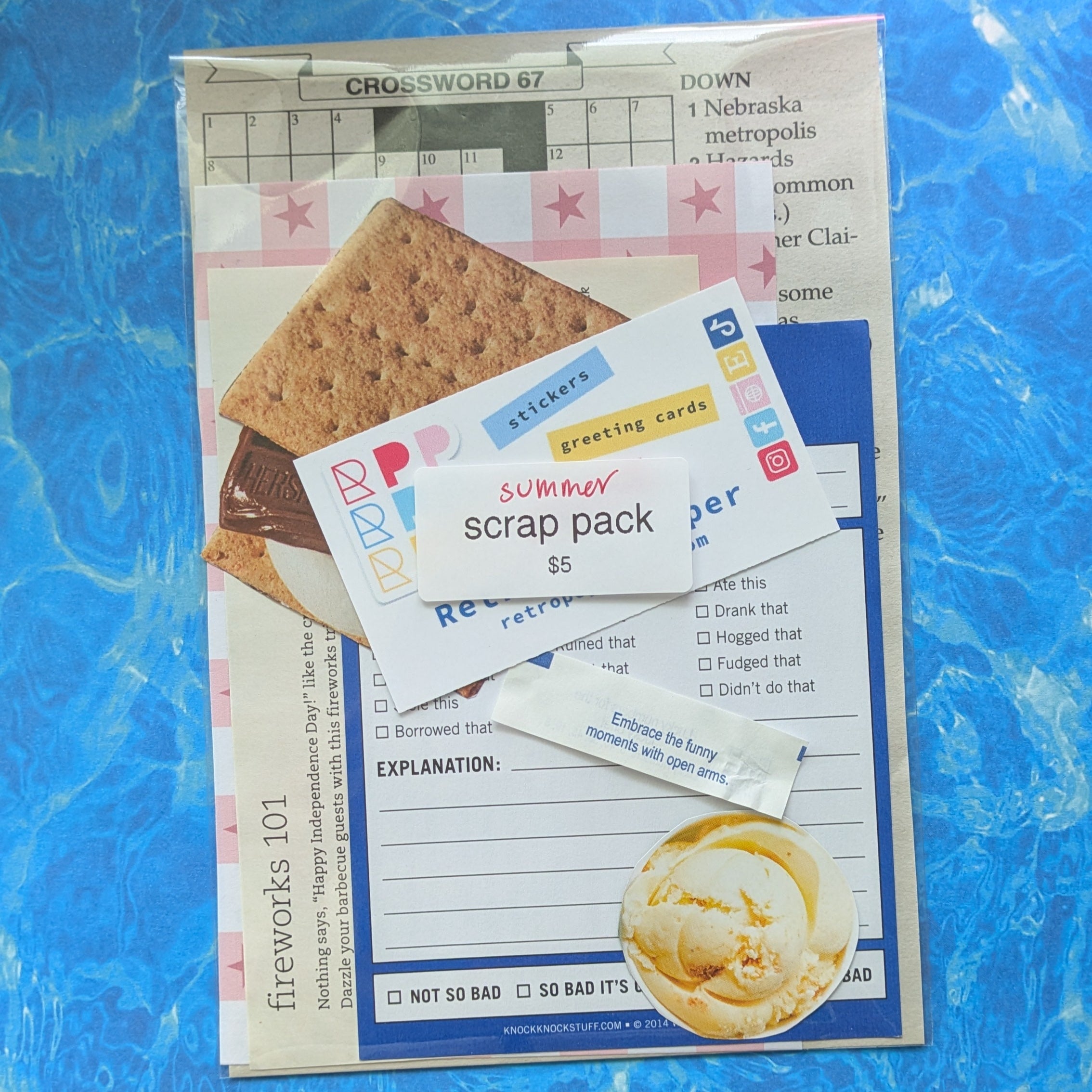 Scrapbooking kit with graham crackers and cards on a blue surface